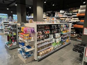 Interieur van een dierenwinkel met displays met voer, speelgoed, bedden en accessoires op stellingen en balies.