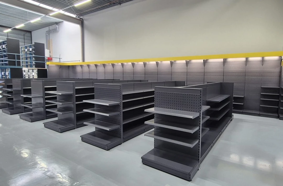 Leeg winkelinterieur met zwarte metalen stellingen en grijze achterwaardwanden in een moderne winkelruimte.