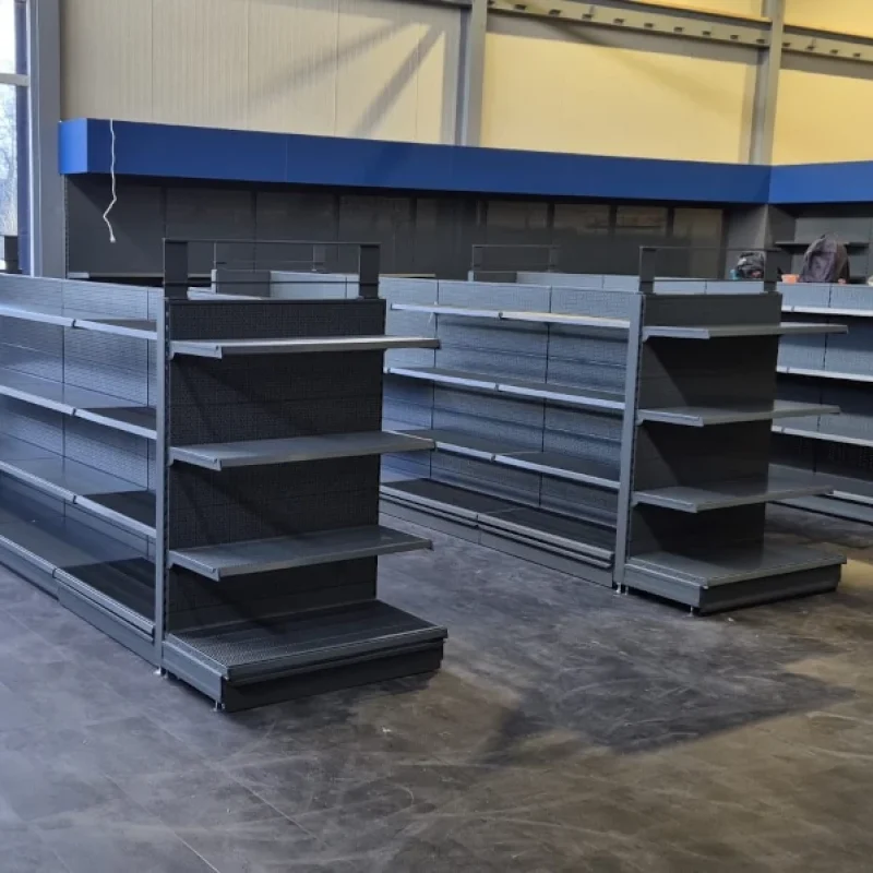 Lege winkelruimte met zwarte metalen stellingen en vitrinekastten in een modern interieur met grote ramen.